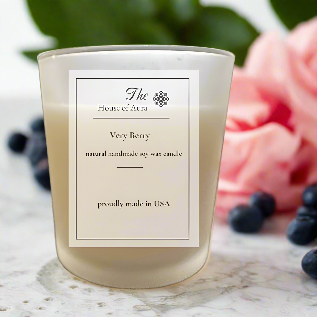 Very Berry soy candle in a frosted glass jar with wooden lid, styled on a pink marble surface with fresh berries. Handmade by The House of Aura.