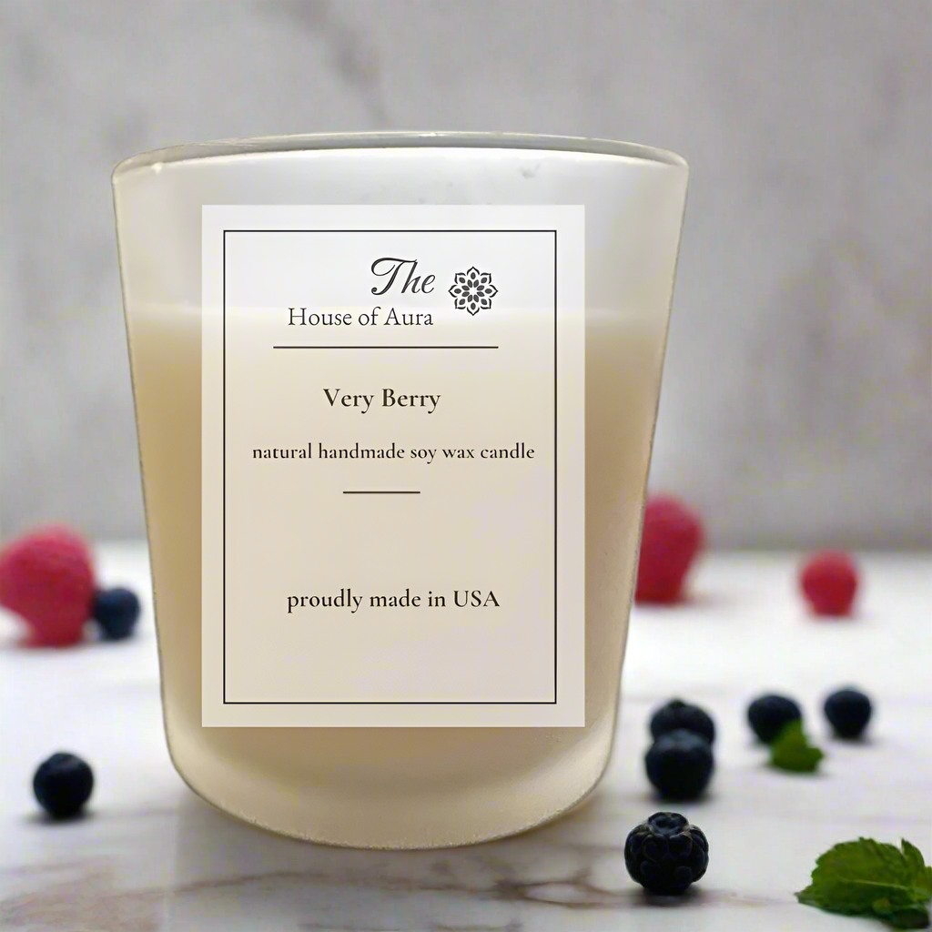 Very Berry soy candle in a frosted glass jar with wooden lid, surrounded by fresh berries. Handmade by The House of Aura.