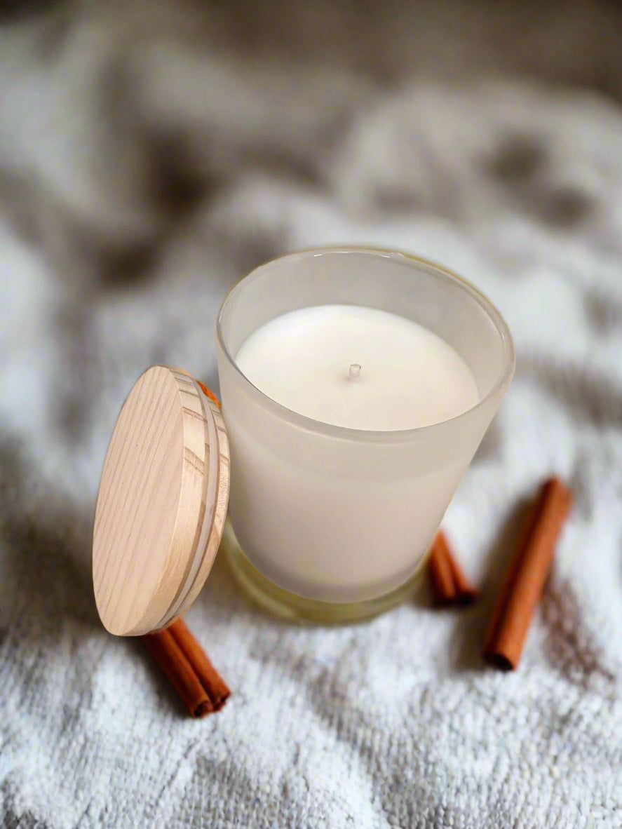Warm cinnamon soy candle burning in cozy fall setting – eco-friendly spiced candle